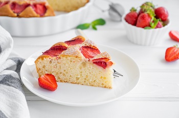 Ein Stück frisch gebackener Erdbeerkuchen auf einem weißen Teller